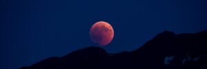 Roter Vollmond hinter Gebirge